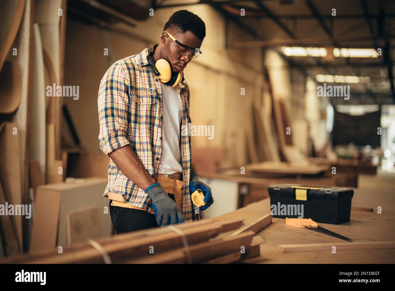 Carpenter man attend to making masterpiece woodworks handcrafted furniture fine measure in wood workshop. Stock Photo