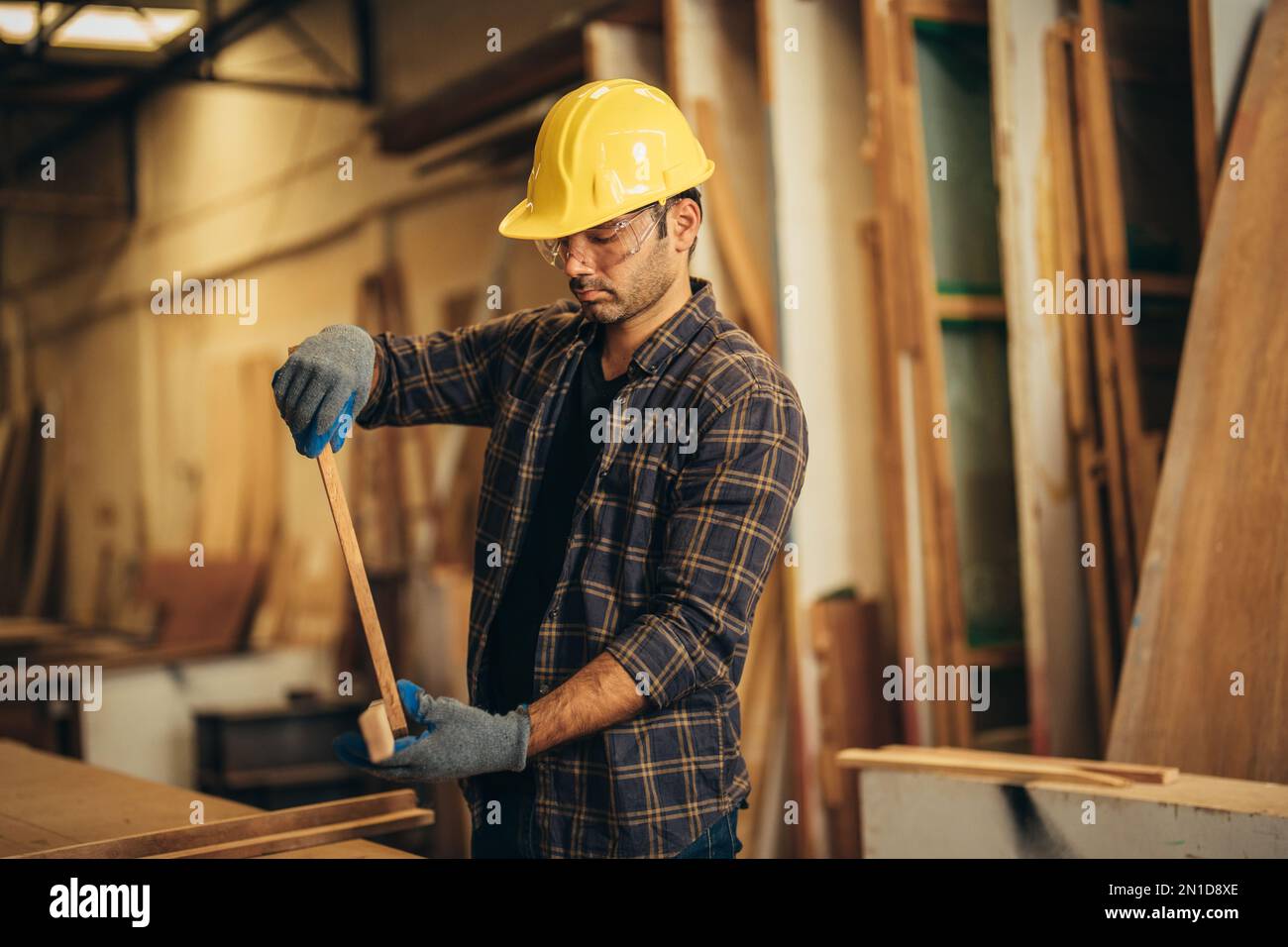 Carpenter man attend to making masterpiece woodworks handcrafted furniture fine measure in wood workshop. Stock Photo