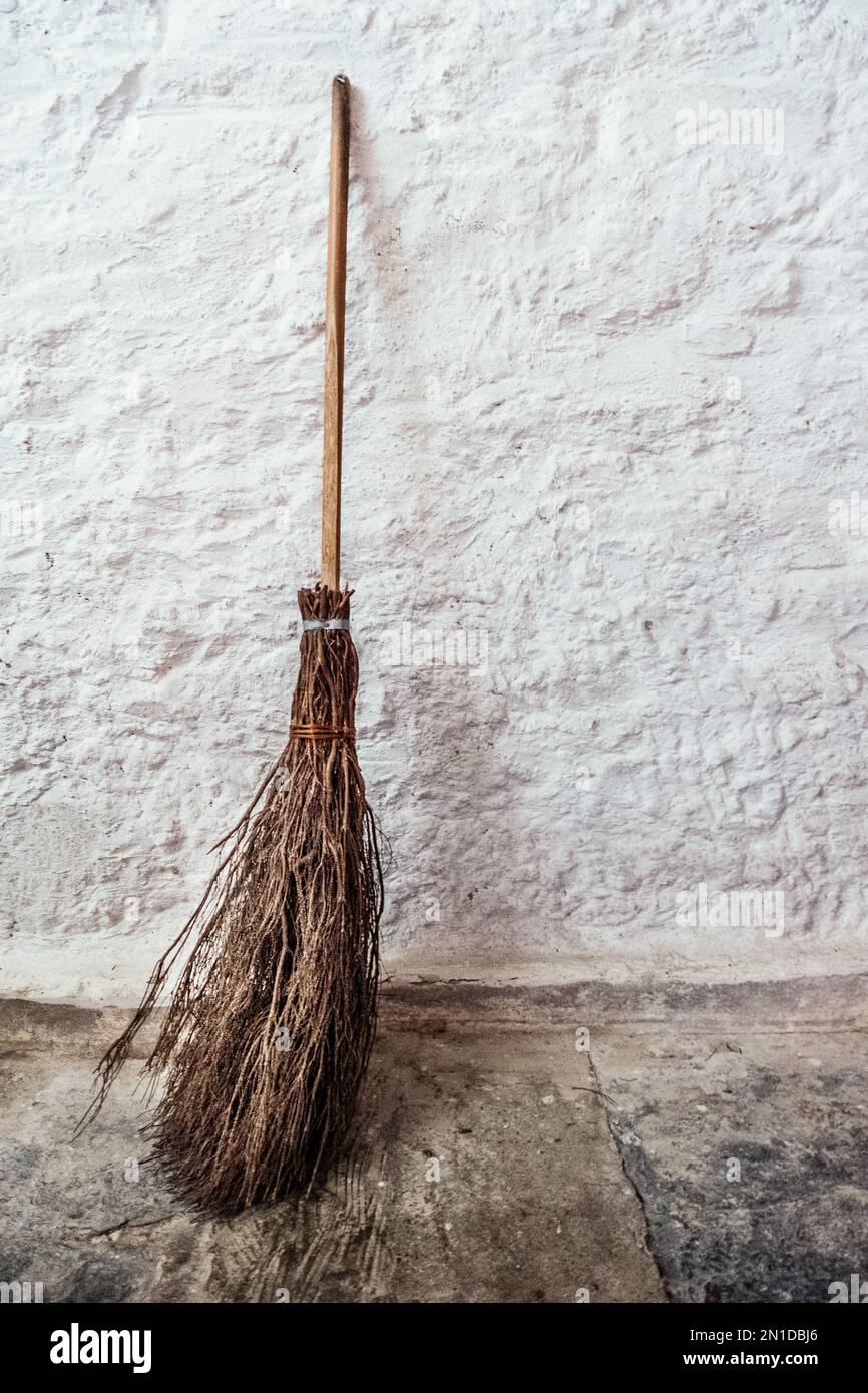 Witches broom propped up against a white washed wall. Stock Photo