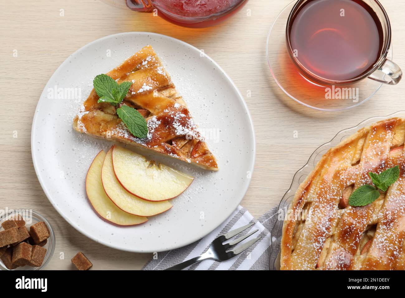 Slice of traditional apple pie served on wooden table, flat lay Stock Photo