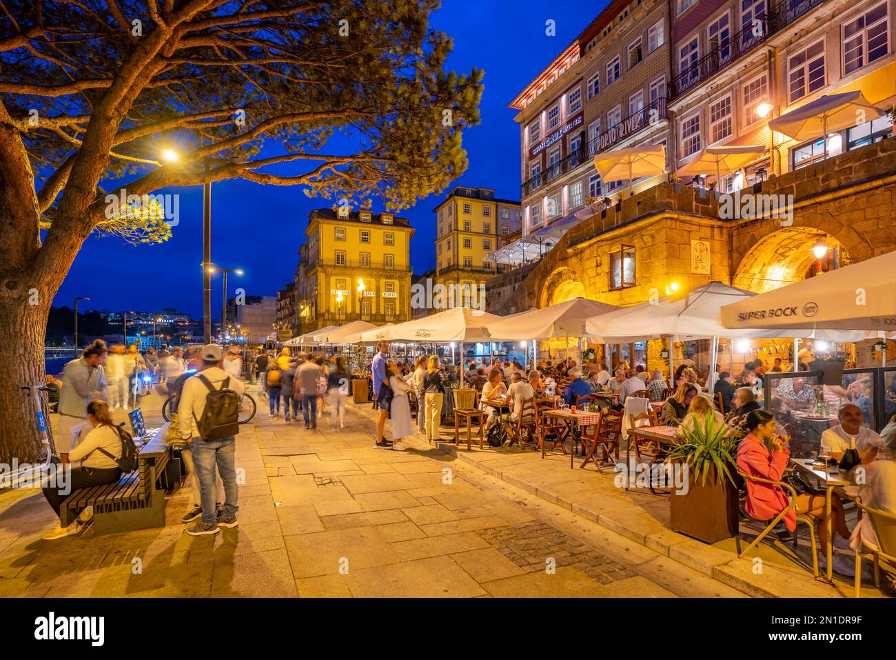 View of bars and restaurants at waterfront of Douro River at dusk, Porto, Norte, Portugal