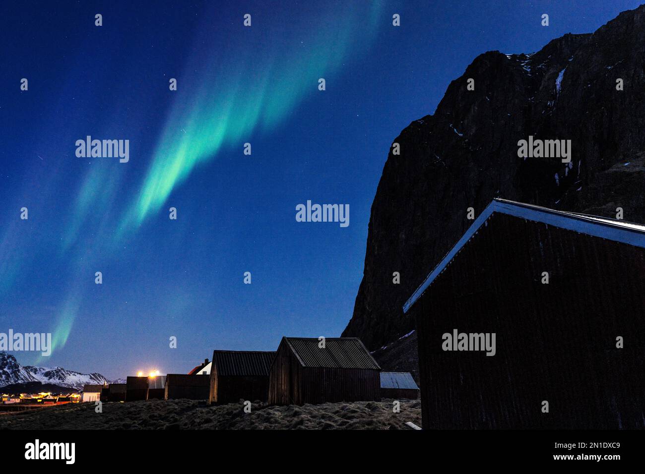 Northern Lights (Aurora Borealis) in the starry night sky over fishermen's cabins, Eggum, Vestvagoy, Nordland county, Lofoten Islands, Norway Stock Photo
