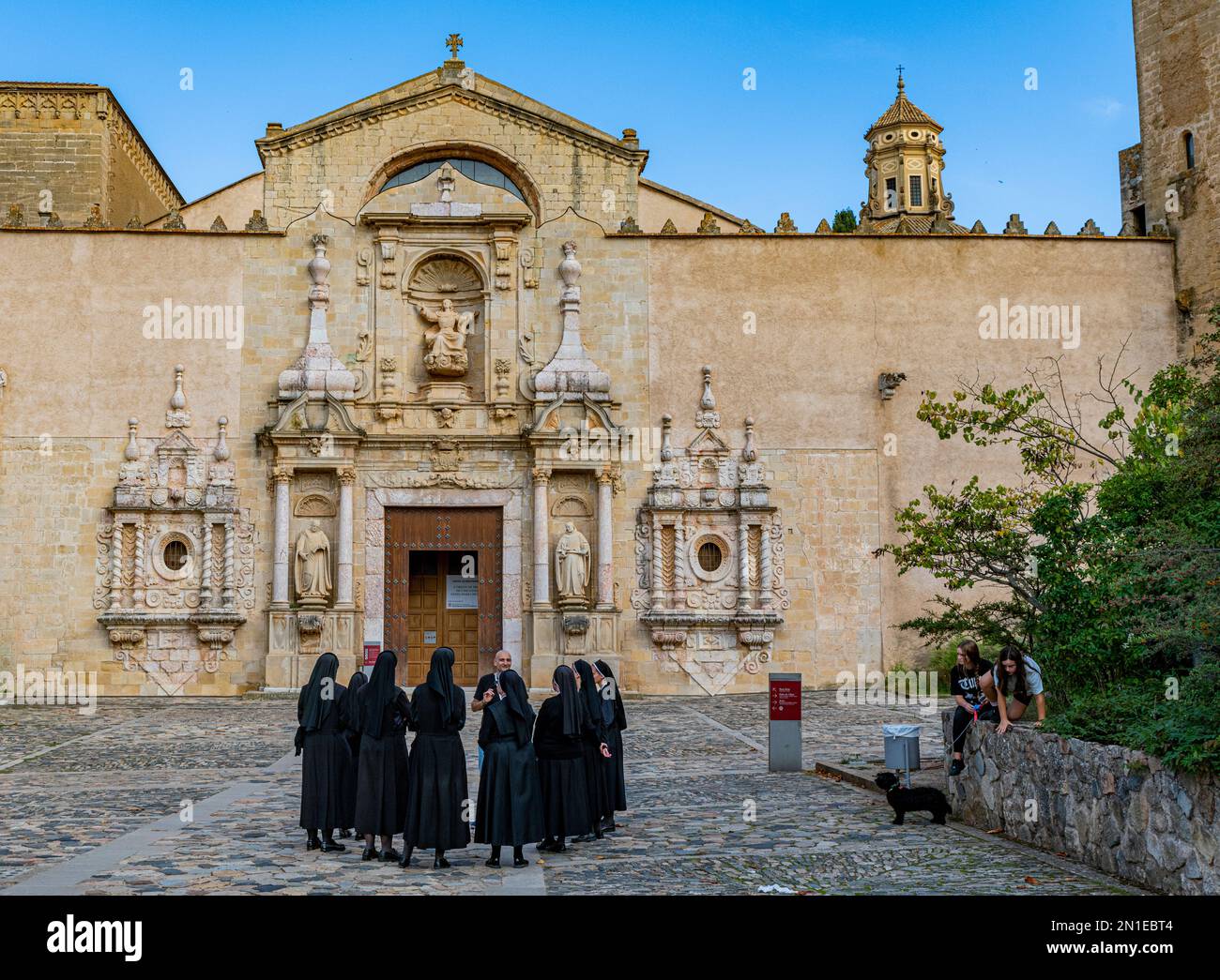Nuns in front of the main portal of the church, Poblet Abbey, UNESCO World Heritage Site, Catalonia, Spain, Europe Stock Photo