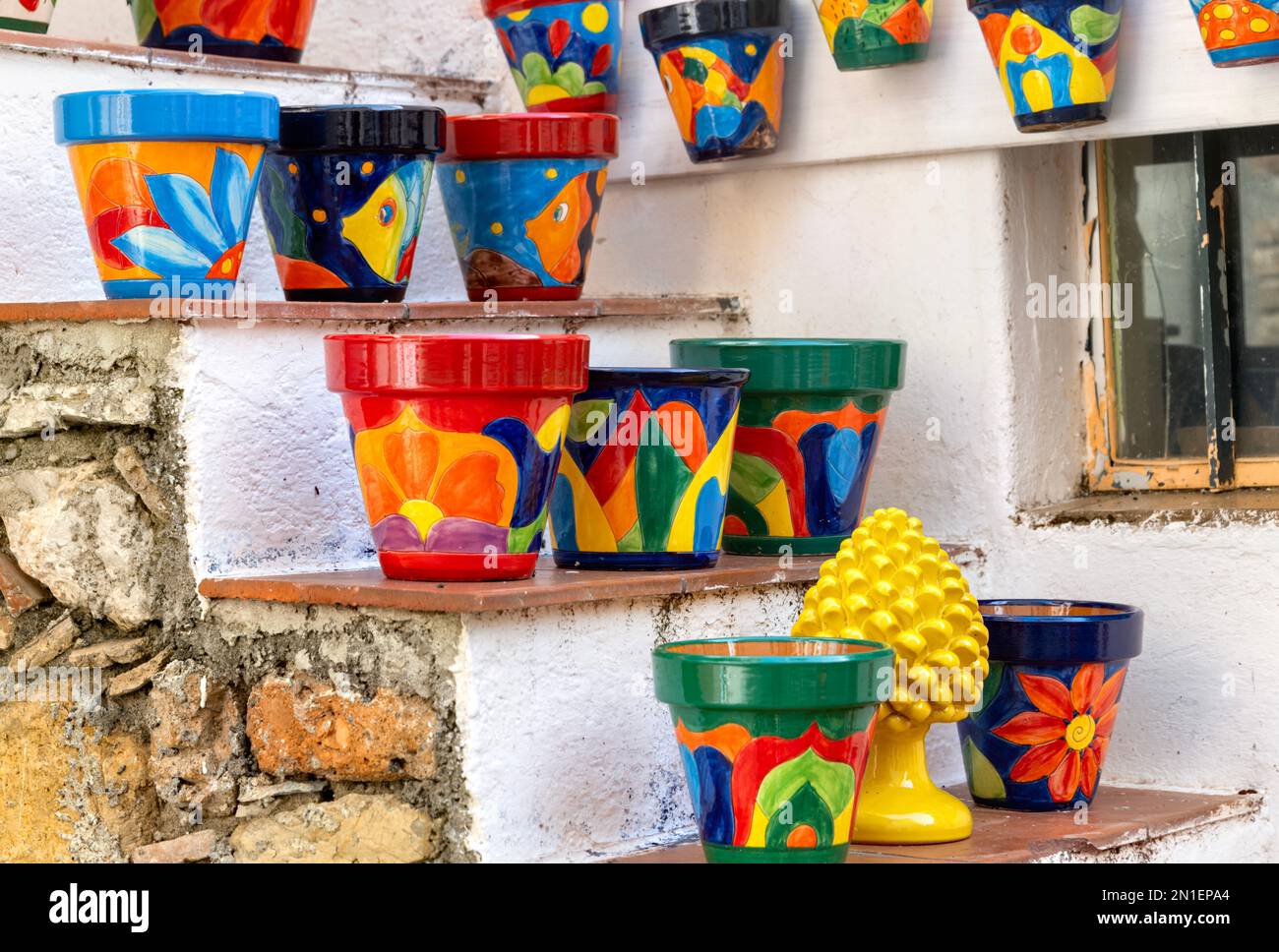 Castelmola, Sicily, Italy, brightly painted colourful ceramic flowerpots for sale on stone steps Stock Photo