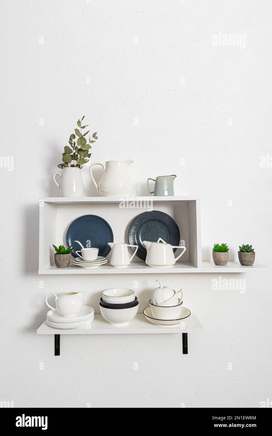 open white wooden shelves with various dishes made of environmentally