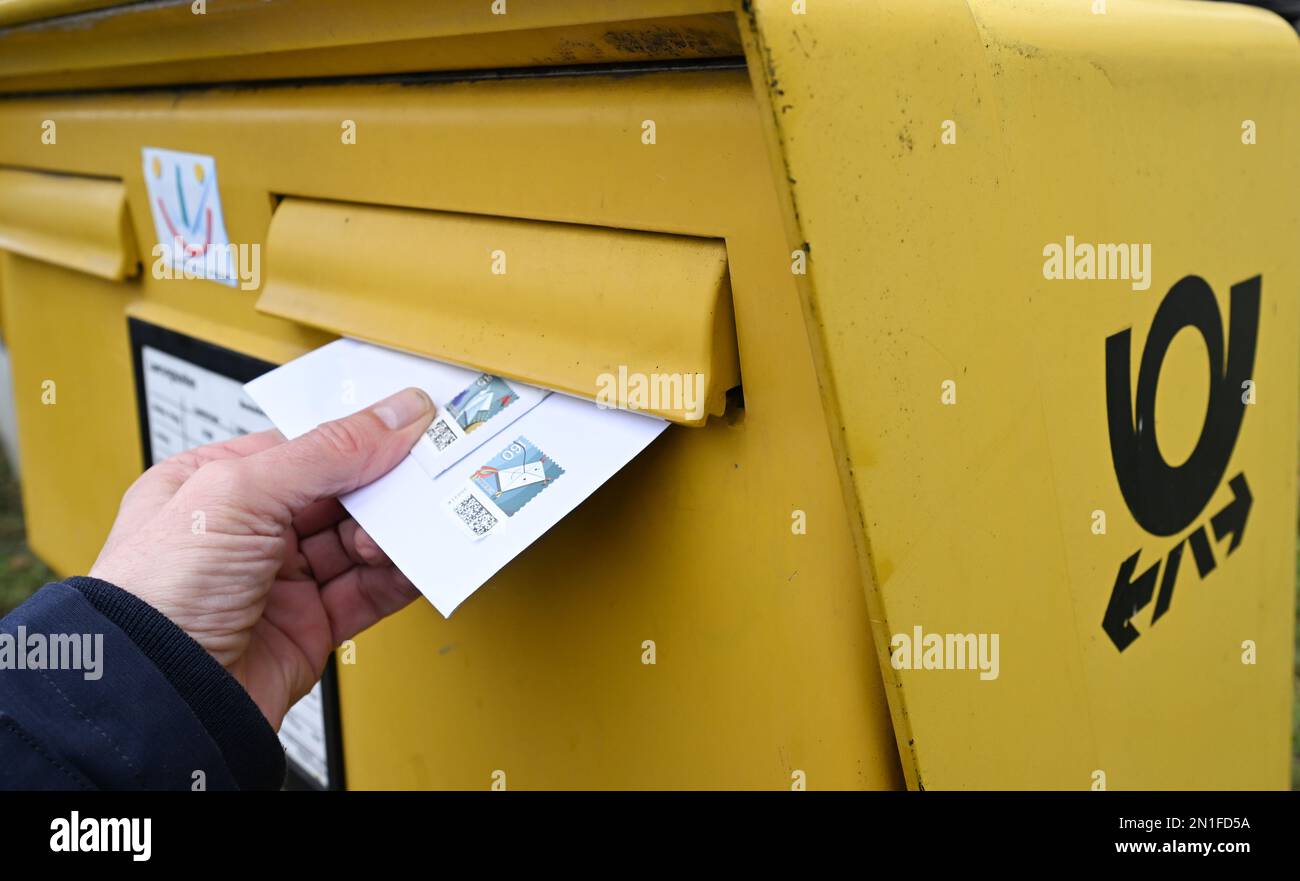 Stuttgart, Germany. 06th Feb, 2023. A hand puts two letters in a  mailbox.Many postal customers in the southwest could again wait in vain for  letters and parcels. The trade union Verdi has