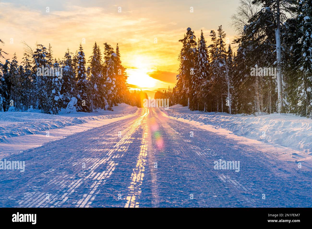 Sunset over an empty snowy road, Lapland, Finland, Europe Stock Photo