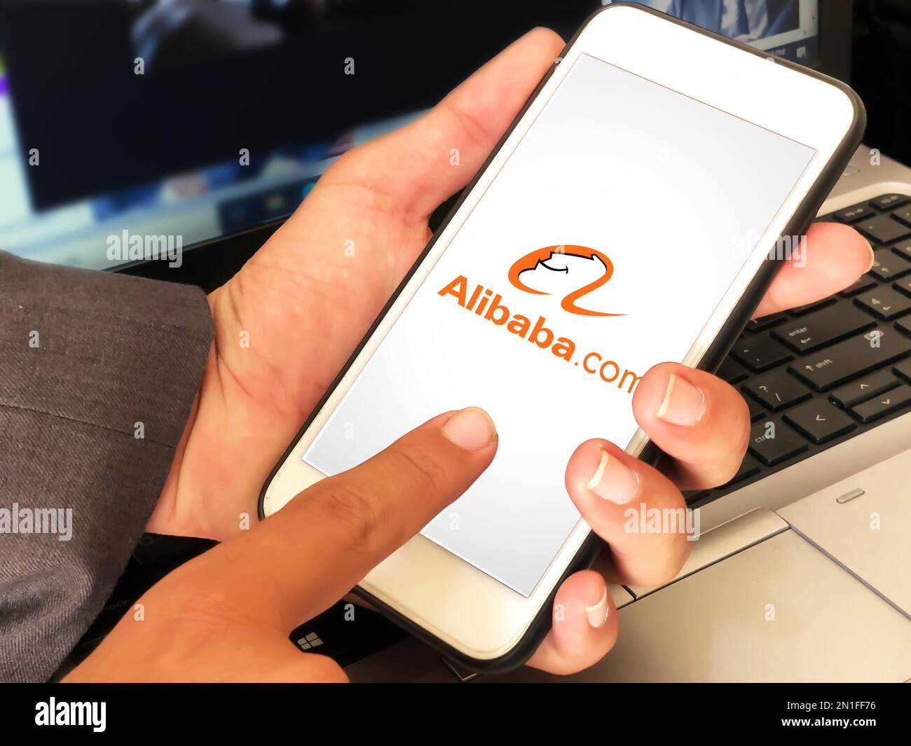 Alibaba ecommerce platform mobile application concept backdrop  editorial. Man using alibaba on mobile Stock Photo