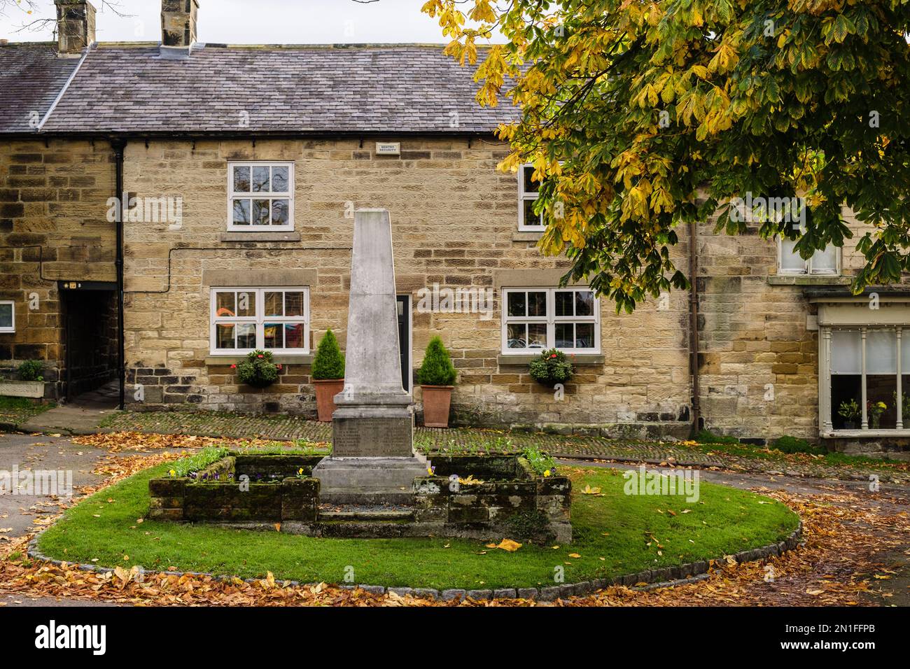 Old stone cottages and WW1memorial on a village street in North York Moors National Park. Osmotherley, Northallerton, north Yorkshire, England, UK Stock Photo