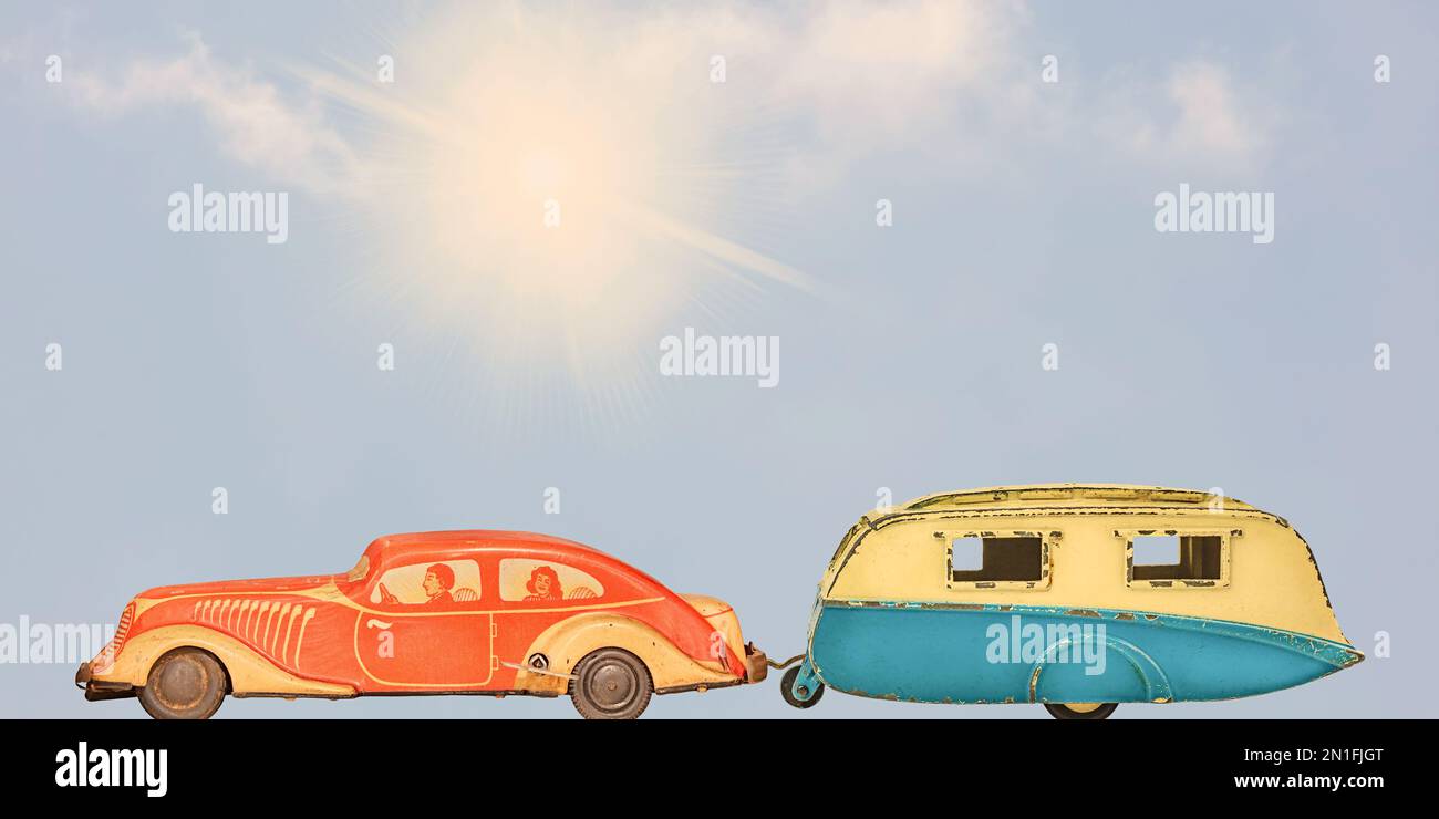 Vintage toy car with classic caravan in front of a summer blue sky with sunshine Stock Photo