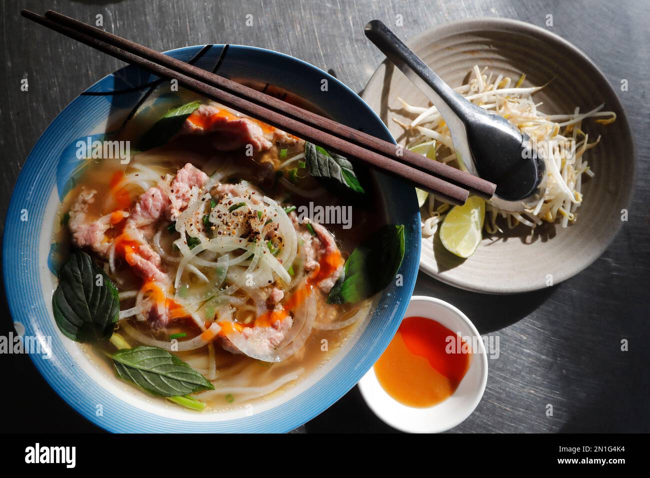 Bowl of Vietnamese traditional pho chicken noodle soup in a street