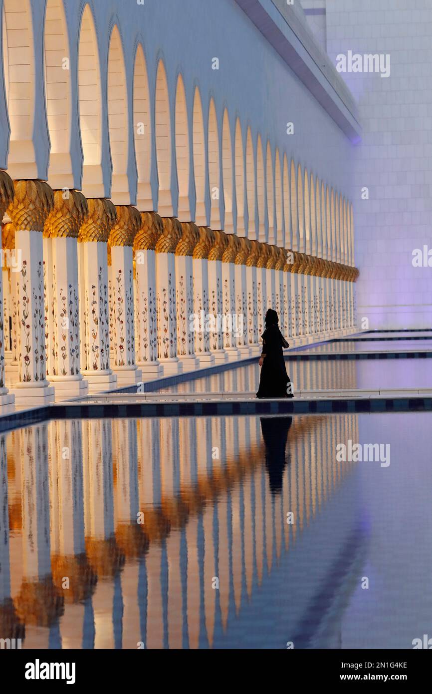 Muslim woman wearing black abaya at Sheikh Zayed Grand Mosque, mosque has 1096 columns on exterior, Abu Dhabi, United Arab Emirates, Middle East Stock Photo