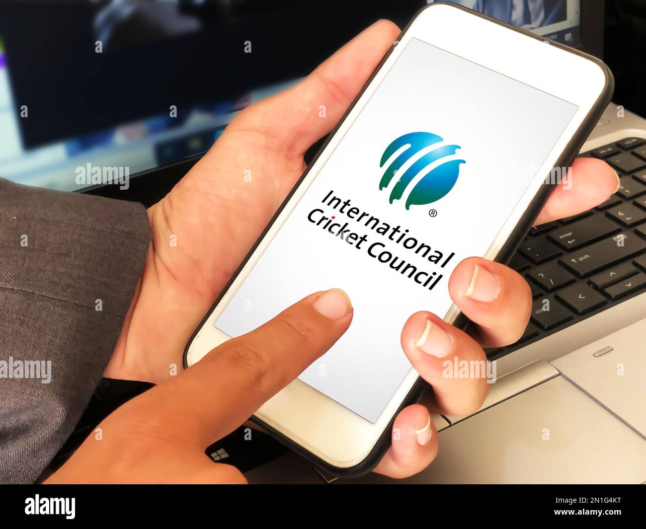 Man using ICC mobile application editorial with laptop in the background