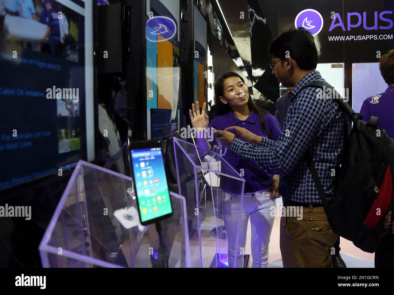 An exhibitor interacts with a visitor at China's APUS Group stall at ...