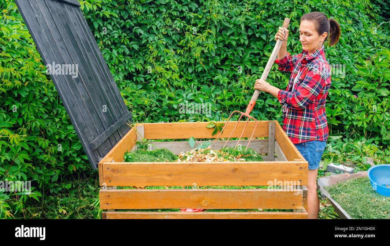 Making compost from organic waste in the garden. A woman stirs waste in
