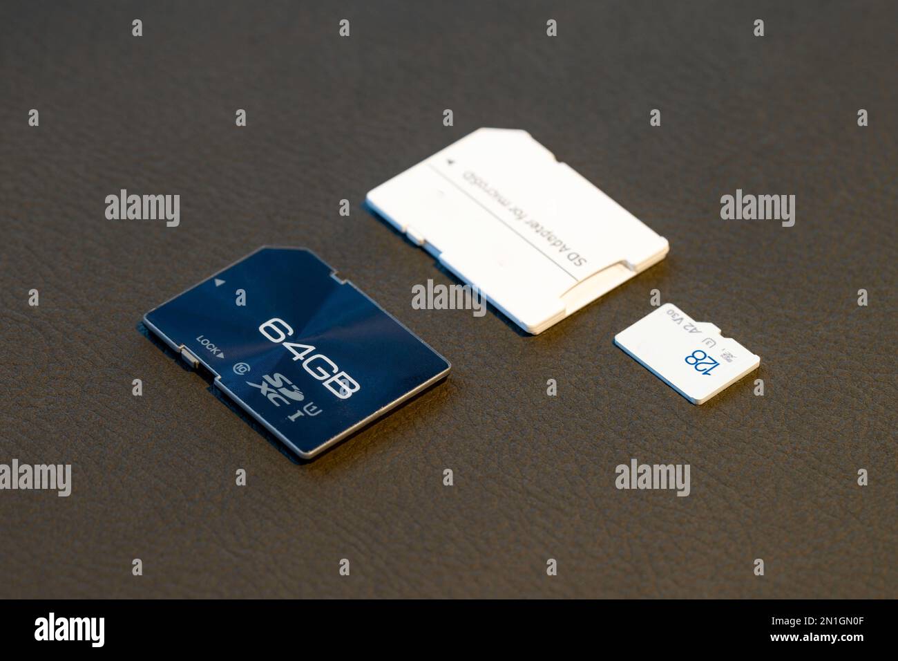 A fast SD Memory Card and Micro SD card with adapter on grey textured background. Stock Photo