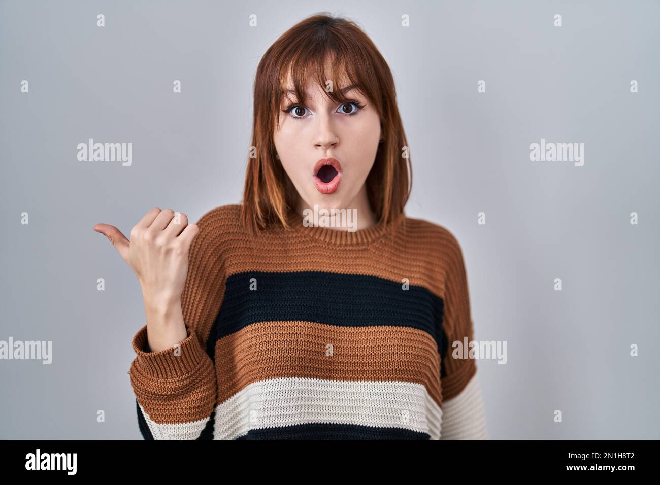 Young Beautiful Woman Wearing Striped Sweater Over Isolated Background