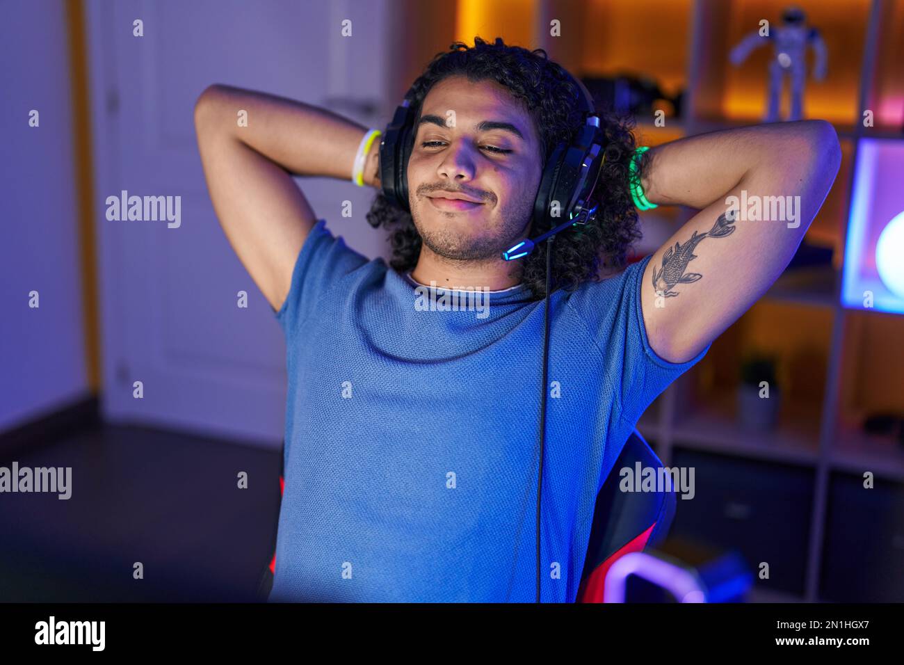 Young latin man streamer smiling confident relaxed with hands on head ...