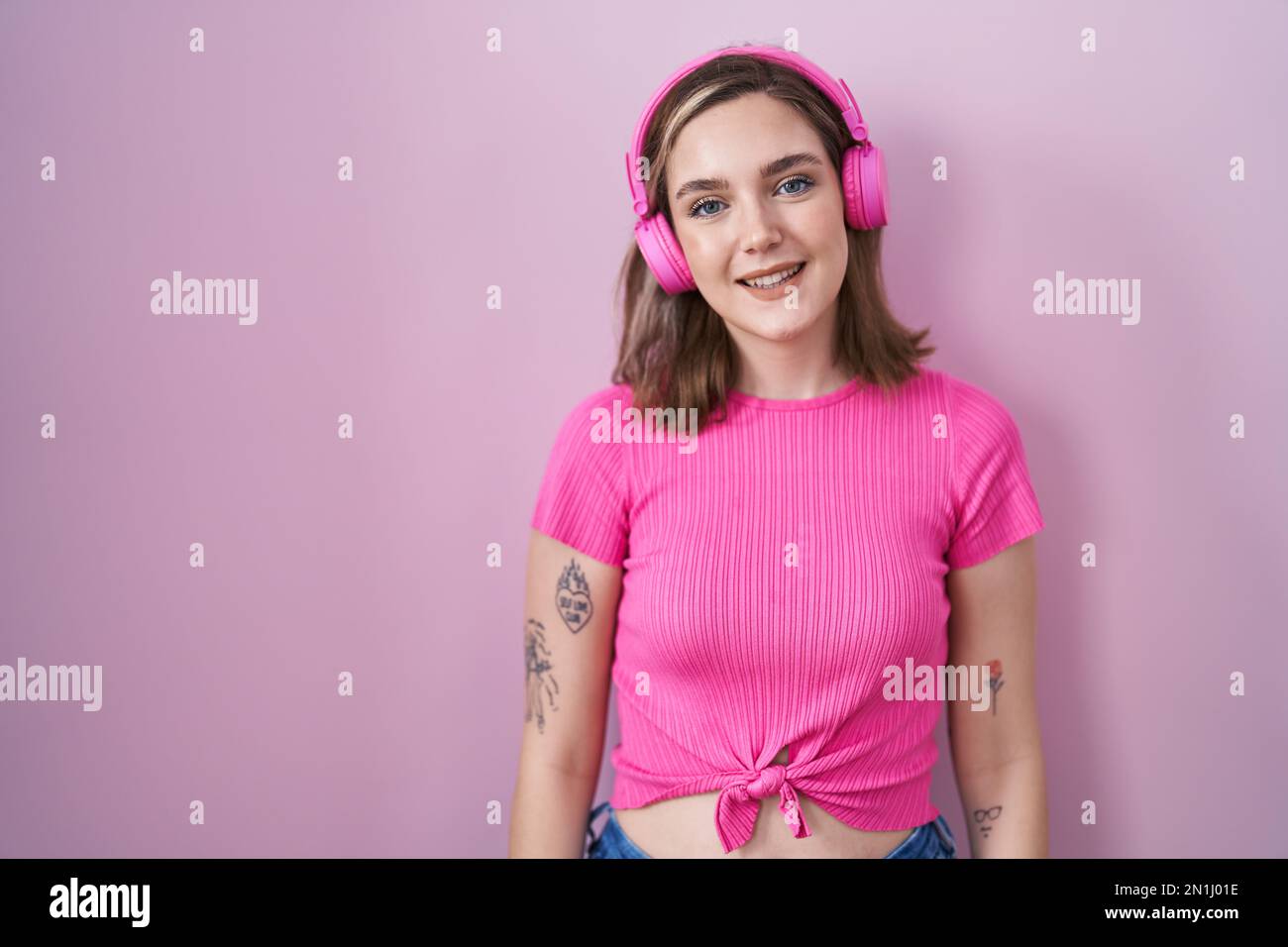 Blonde caucasian woman listening to music using headphones looking ...