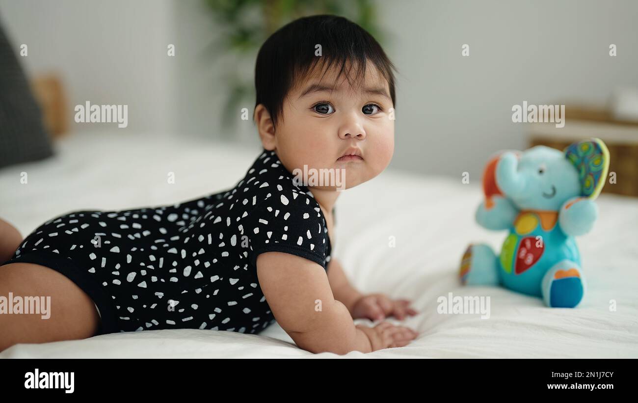 Adorable hispanic baby lying on bed at bedroom Stock Photo - Alamy