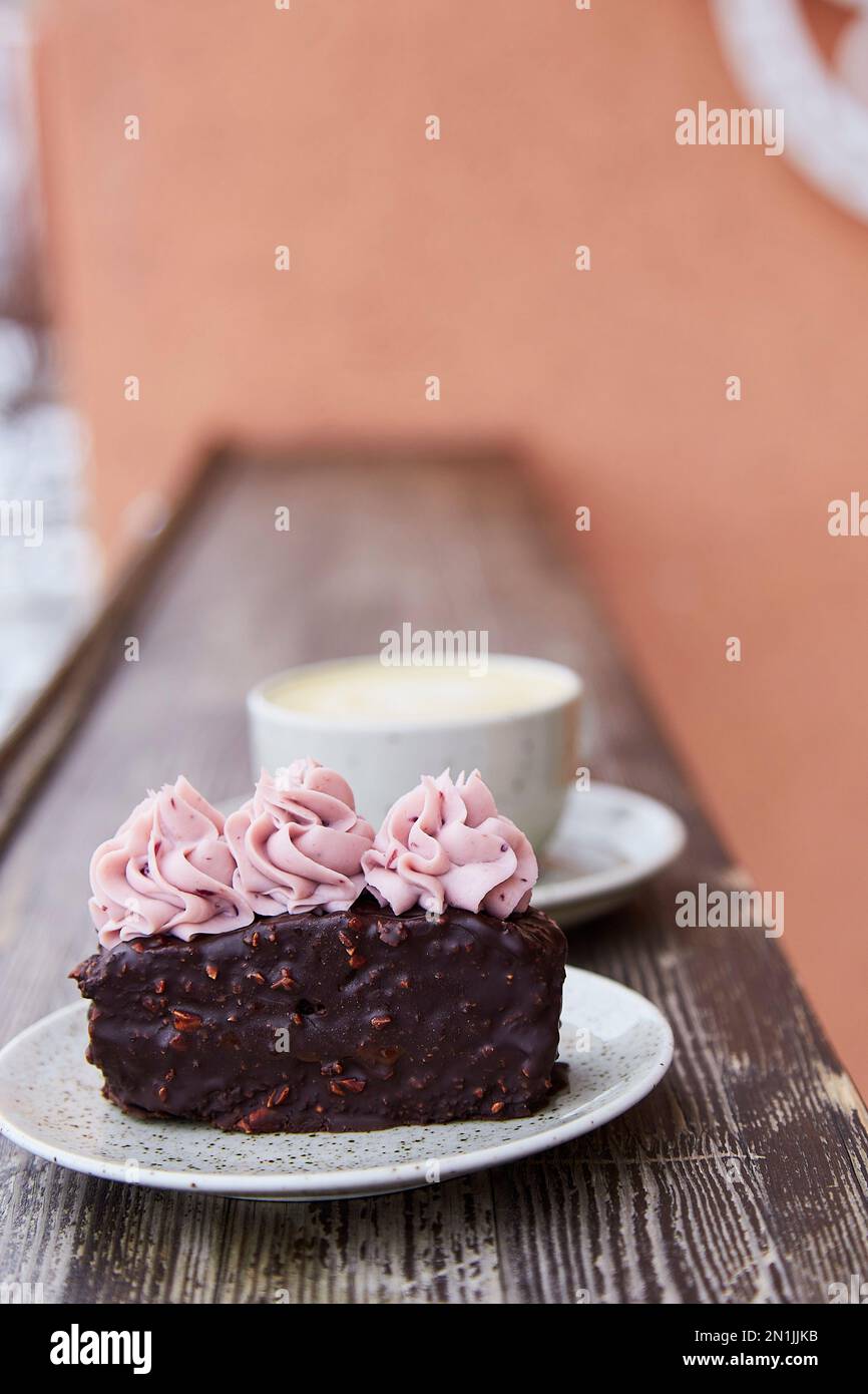 Vegan brownie cake with cup od cappuccino. Coffee with dessert outside aesthetics, Stock Photo