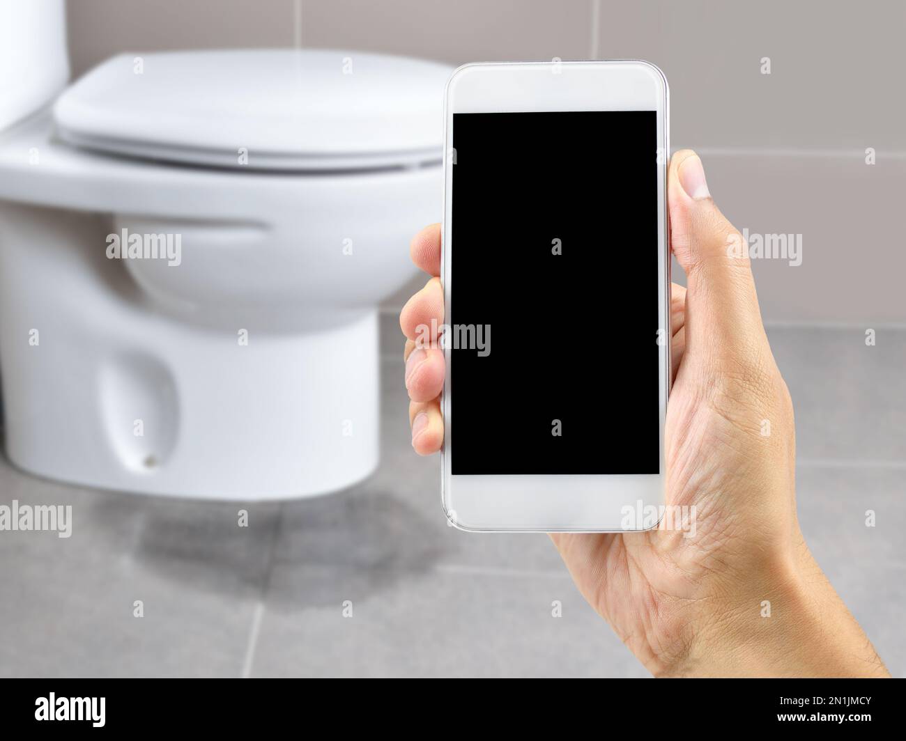 A hand holding a smartphone to call the professional to repair a water