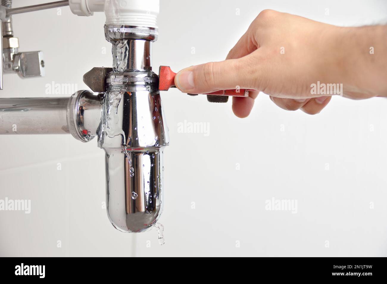 plumber fixing sink pipe with adjustable wrench Stock Photo