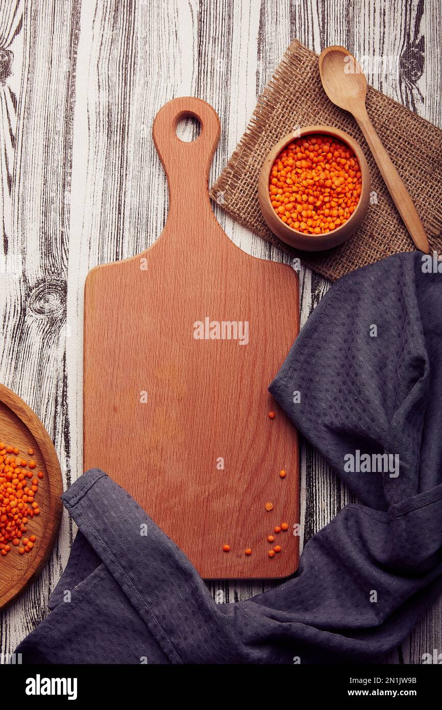 Wooden cutting board mock up, copy space. Raw no cooking lentil. Healthy superfood on the natural background. Aesthetics healthy vegan product. Stock Photo