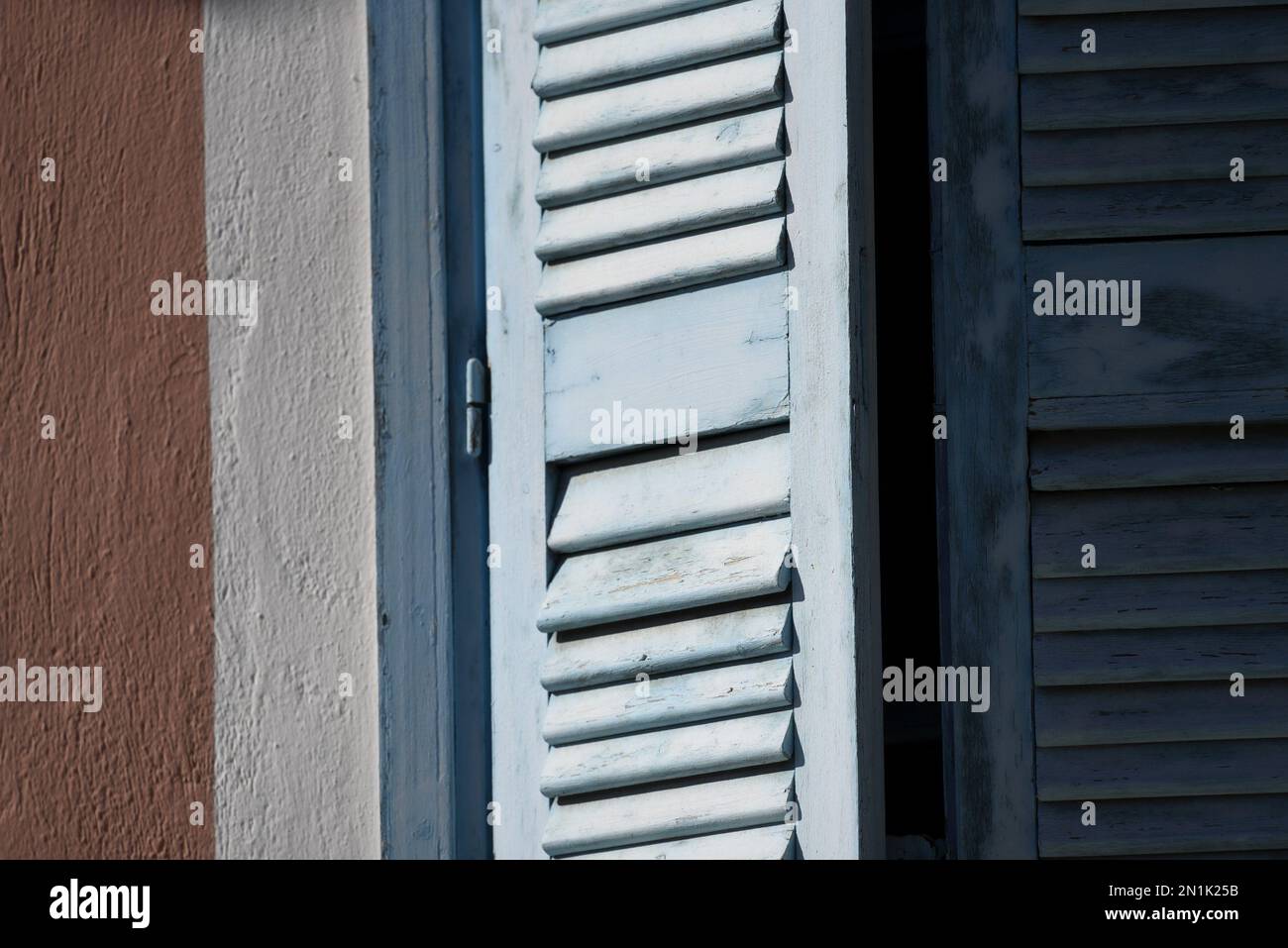 Old rural house light blue wooden window shutters with white trim on a ...