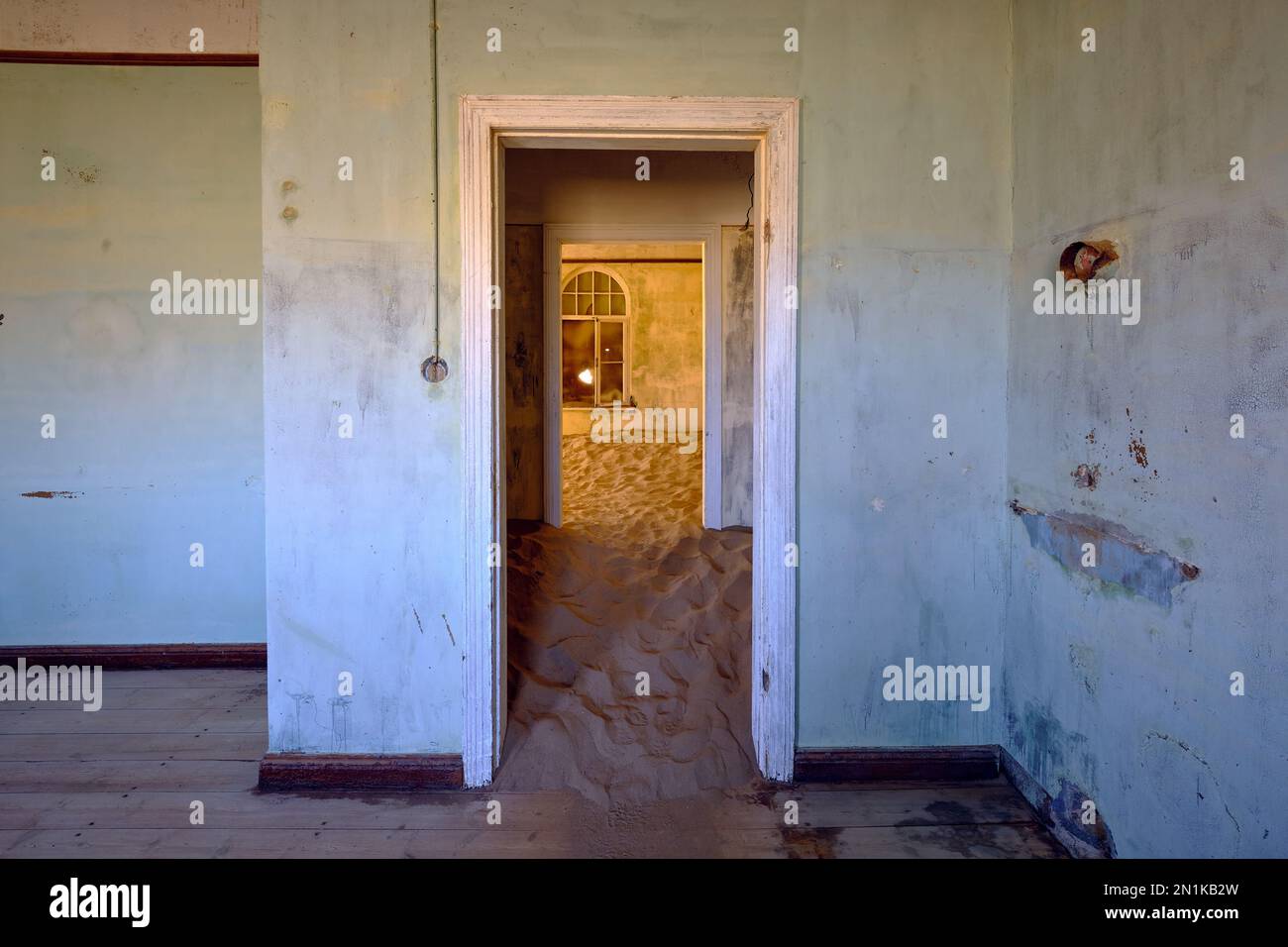 Sandfilled room and view through doorways in Kolmanskop Ghost Town, Namibia. Creative