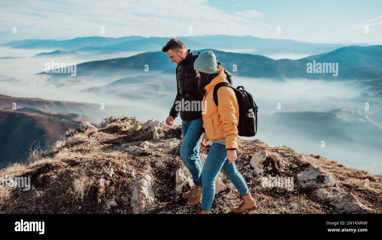 happy couple man and woman tourist at top of mountain during a hike in ...