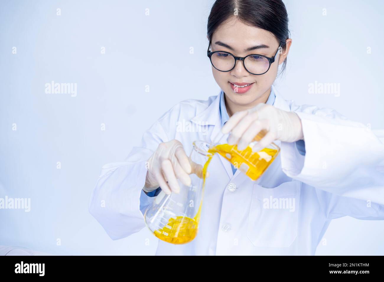 laboratory researcher holding medical glass bottle with yellow liquid