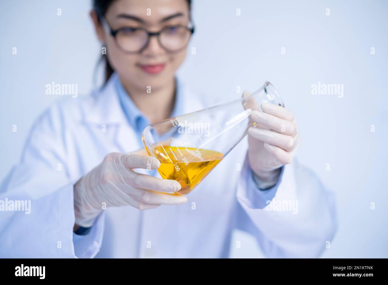 laboratory researcher holding medical glass bottle with yellow liquid