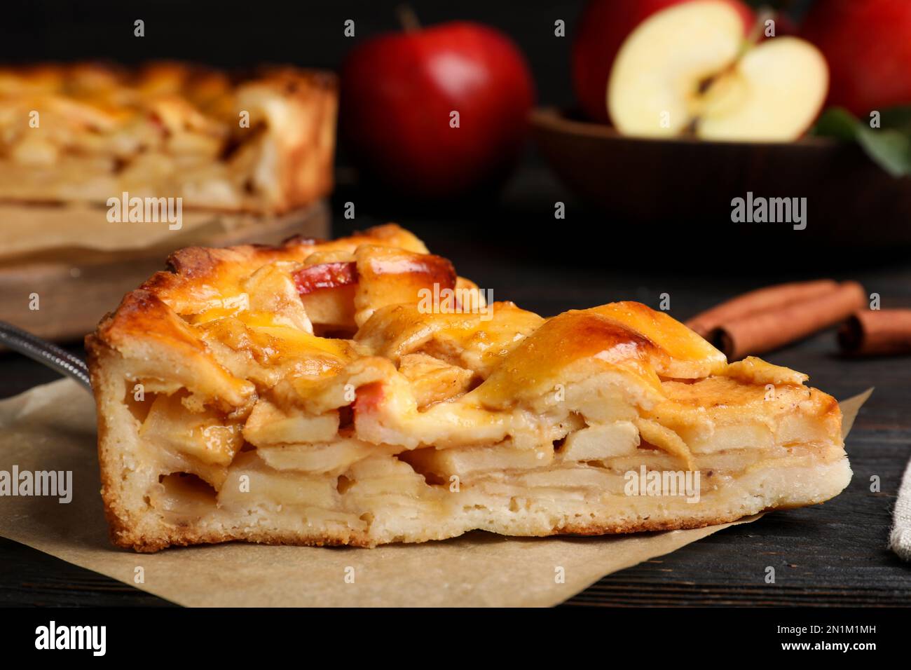 Slice of traditional apple pie on black wooden table, closeup Stock Photo
