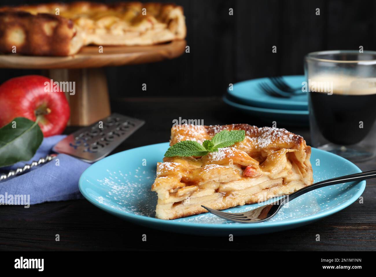 Slice of traditional apple pie served on black wooden table Stock Photo