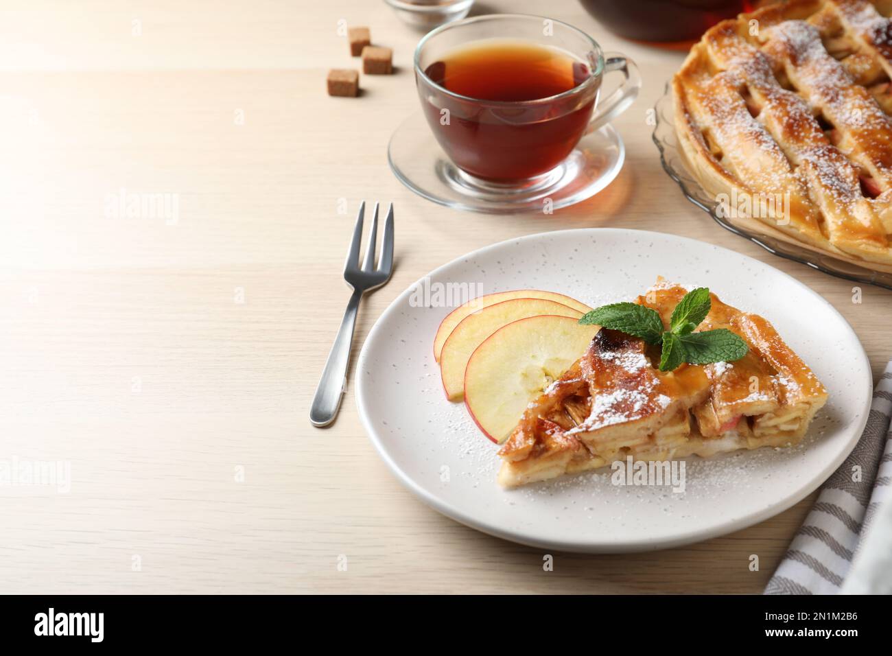 Slice of traditional apple pie served on wooden table. Space for text Stock Photo