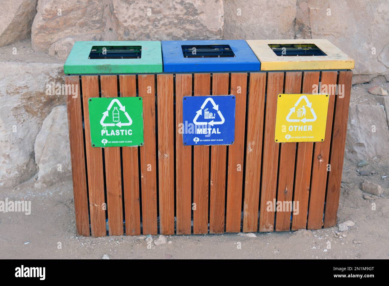 A wooden trash bin for different garbage with an inscription in English