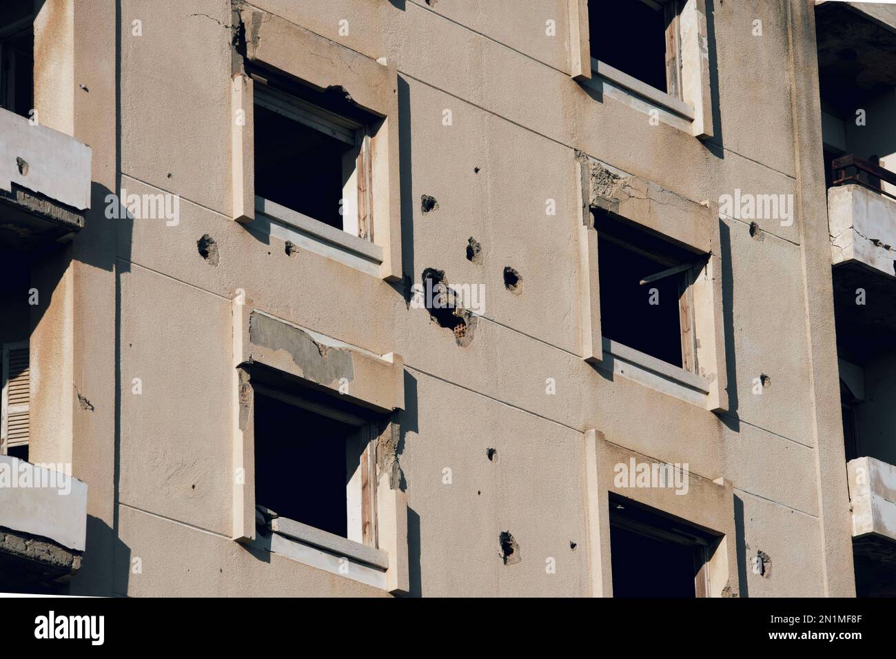 A front facade of an abandoned hotel with visible damages after bombing Stock Photo