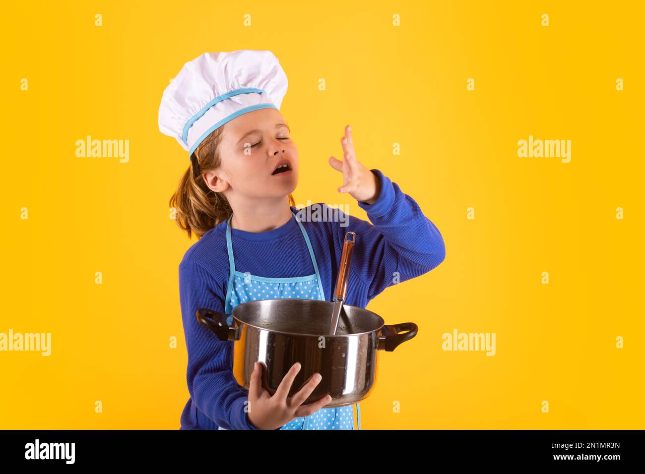 Kid cook with cooking pot and ladle. Kid in cooker uniform and chef hat