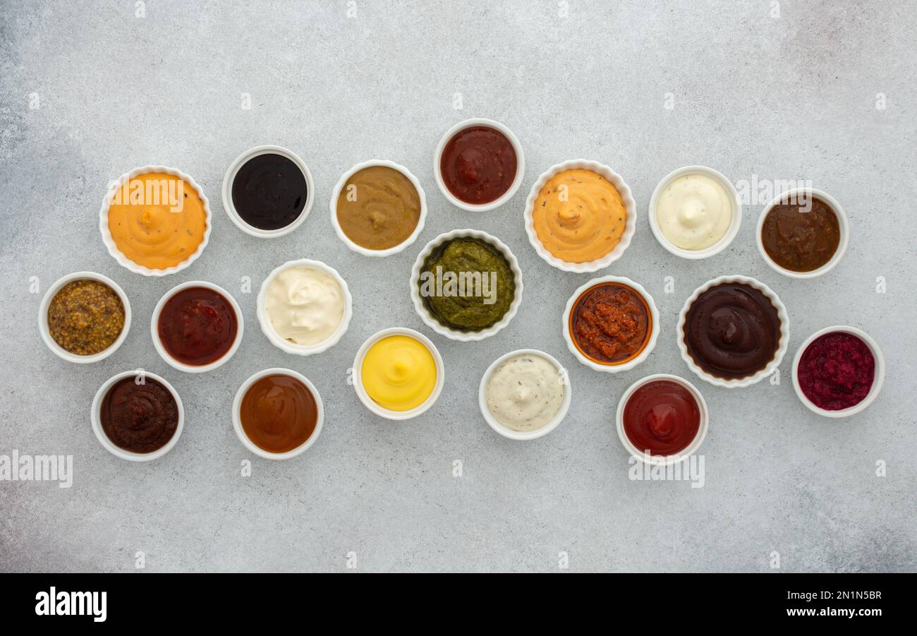 Different types of sauces in bowls , ketchup and mayonnaise, pesto and