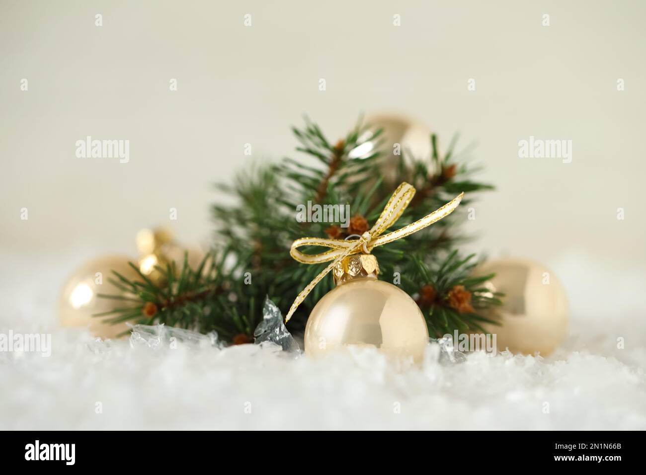 Beautiful Christmas balls and fir branch on snow against white ...