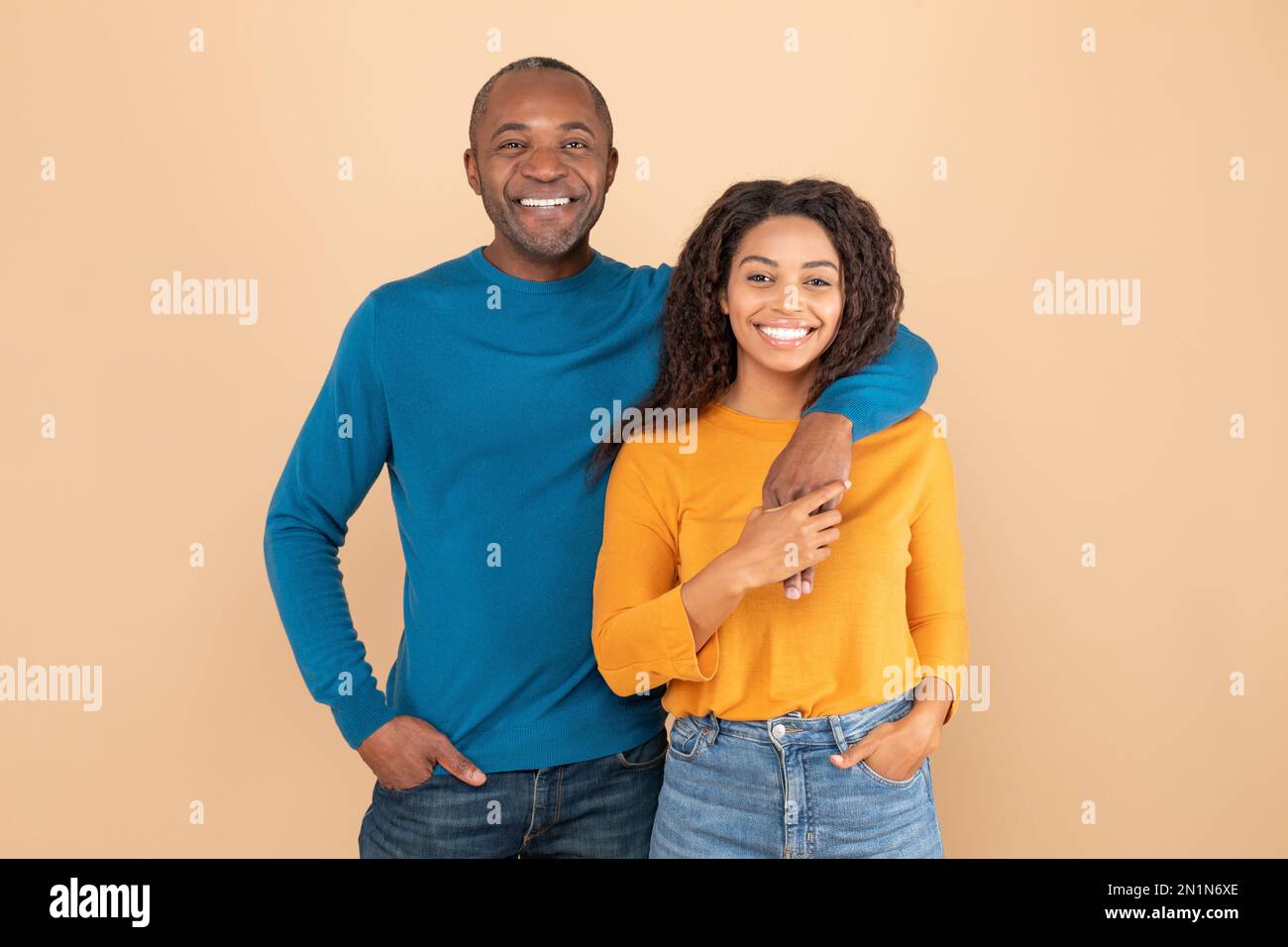 Happy african american couple hugging and smiling at camera, standing ...