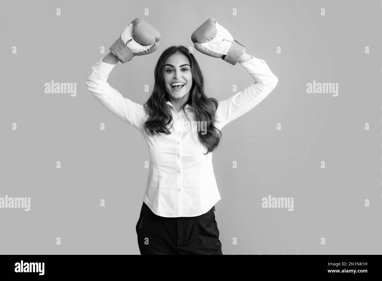 Woman in boxing gloves. Creative business portrait of a woman in an office suit with boxing