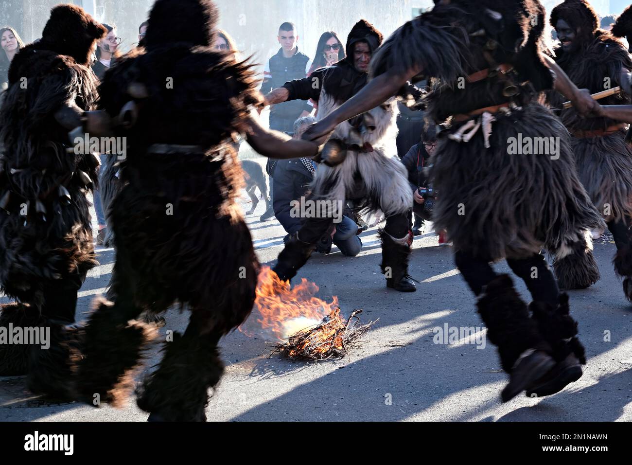 Group of masked execute a dancing ritual around a bonfire Stock Photo