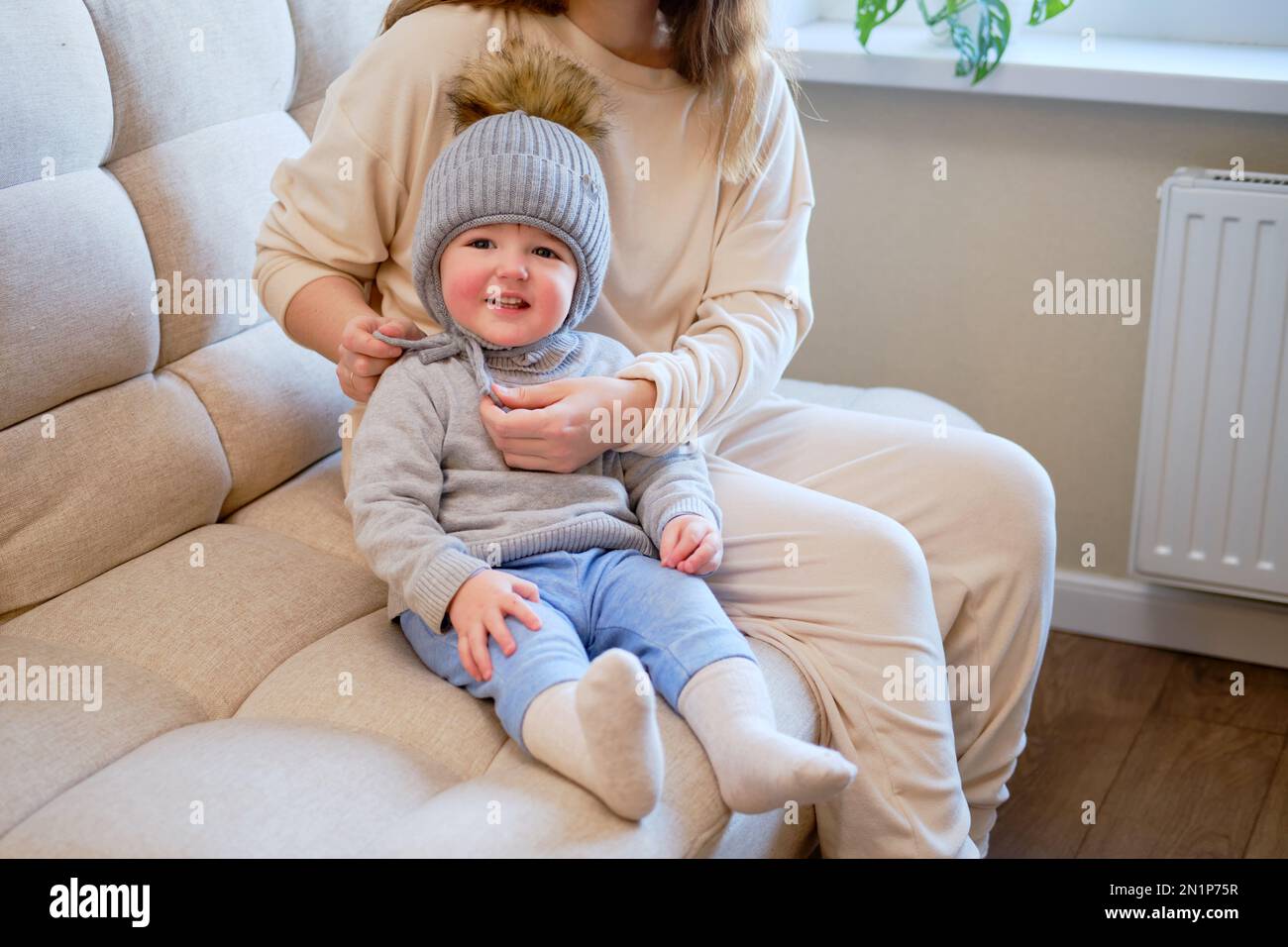 Child is dressed in warm winter clothes for a walk outside. Woman