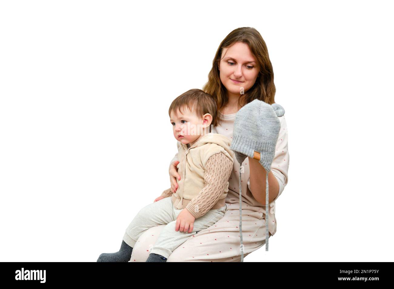 Mother puts a warm scarf on the toddler baby, isolated on a white  background. Woman mom dressing warm clothes on child for winter walk in  cold weather Stock Photo