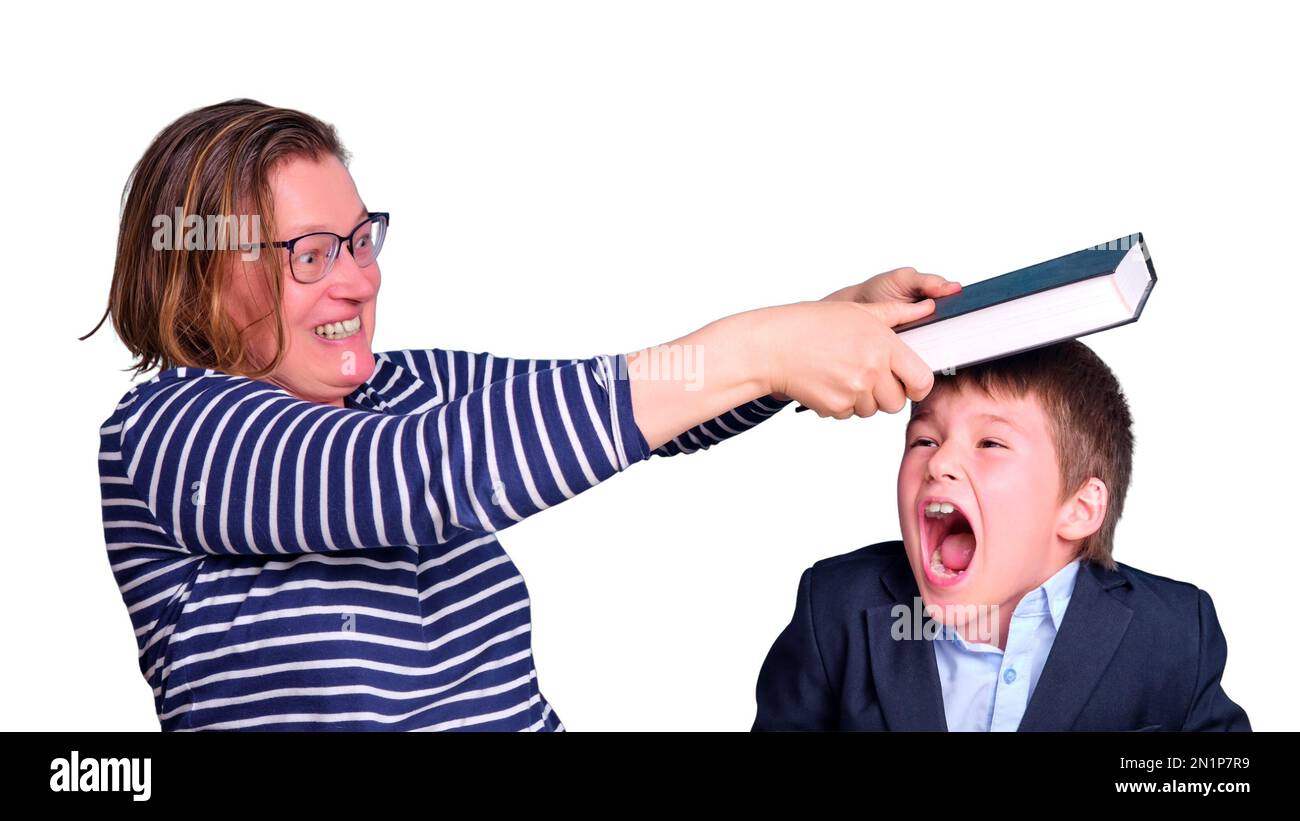 Angry teacher hits junior boy with book at desk, learning problems in primary school, isolated on a white background Stock Photo