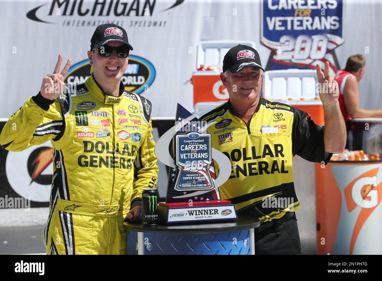 Kyle Busch stands with crew chief Jerry Baxter and the winner's trophy