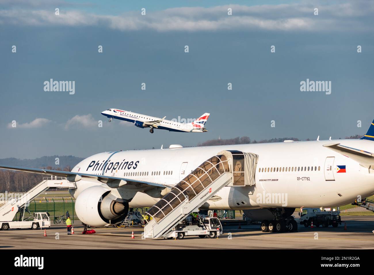 Zurich, Switzerland, January 20,2023 British airways Embraer E-190SR aircraft is taking off behind a Philippines Boeing 777-3F6-ER government jet Stock Photo