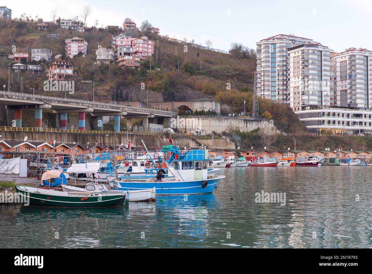 Arakli fishing harbor, Trabzon, Turkey. Coastal view with modern buildings and traditional small fishing boats Stock Photo